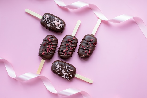 Pastel de paletas de chocolate en forma de helado sobre un fondo rosa Concepto dulces vacaciones