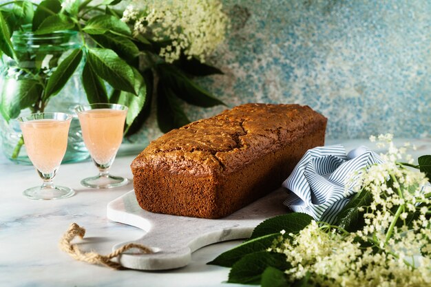 Pastel de pan dulce de verano sobre una mesa con flores y una bebida en vasos. postre para el brunch o el desayuno de la mañana