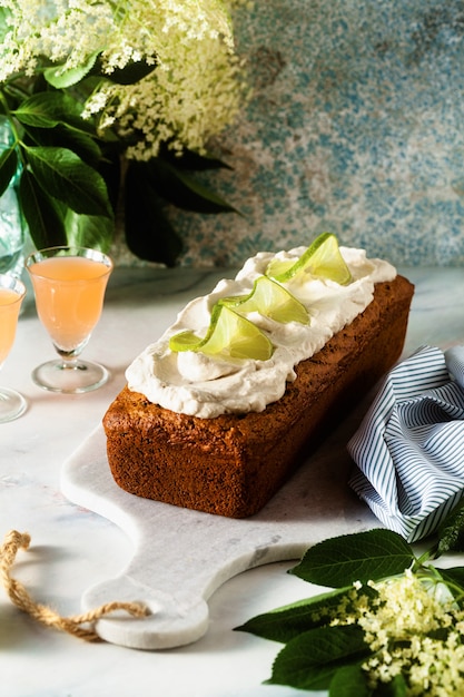 Pastel de pan dulce de verano sobre una mesa con flores y una bebida en vasos. postre para el brunch o el desayuno de la mañana