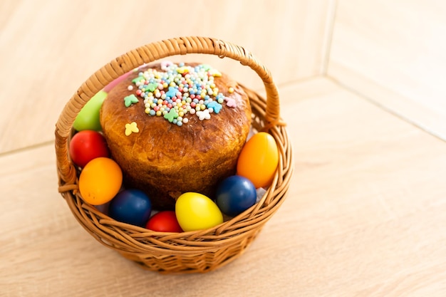 Pastel de Pascua con chispas, huevos pintados y flores sobre mesa de madera, puesta plana. Espacio para texto