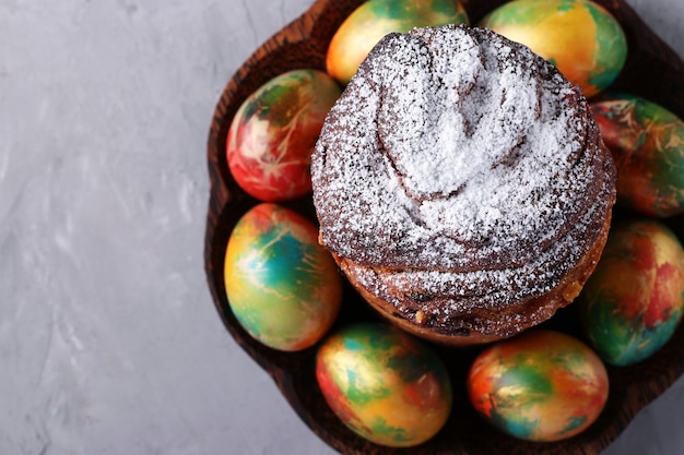 Pastel de Pascua Craffin y huevos coloridos de mármol sobre superficie gris