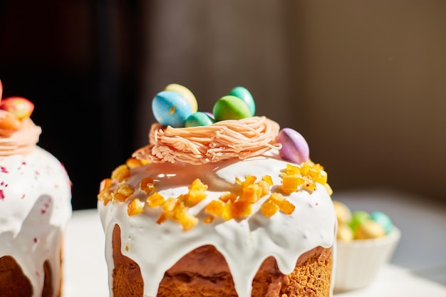 Pastel de pascua con decoración de huevos de chocolate en mesa de madera blanca