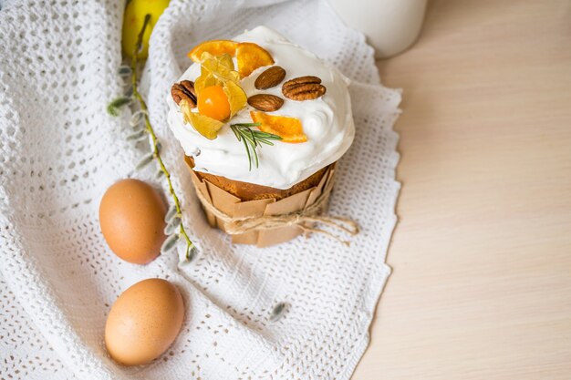 Pastel de Pascua esmaltado decorado con naranjas y huevos en la mesa de madera Felices vacaciones de Pascua