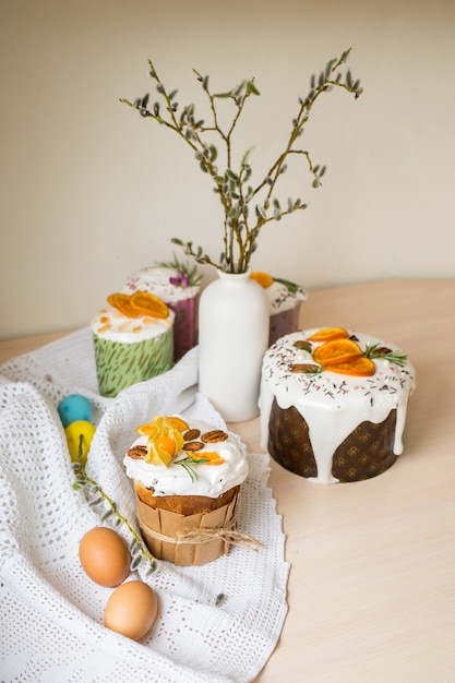 Pastel de Pascua esmaltado decorado con naranjas y huevos en la mesa de madera Felices vacaciones de Pascua