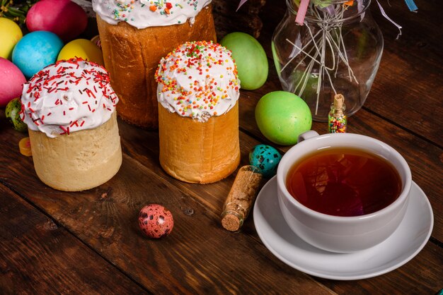 Pastel de Pascua y huevos coloridos con taza de té
