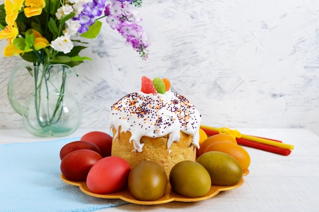 Pastel de Pascua y huevos pintados en un plato sobre un fondo de madera