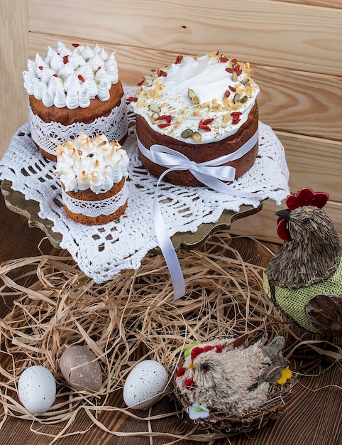 Pastel de Pascua kulich Pan dulce tradicional de Pascua decorado con merengue y huevos en forma de bastón de caramelo en un plato sobre fondo de mesa de madera