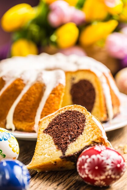 Pastel de Pascua. Pastel de mármol tradicional anillo con decotación de pascua. Huevos de Pascua y tulipanes de primavera.