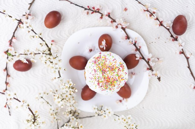 Pastel de Pascua y rama floreciente de huevos pintados.