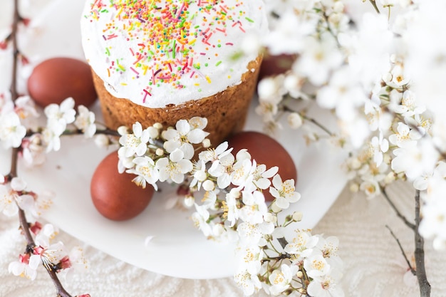 Pastel de Pascua y rama floreciente de huevos pintados.