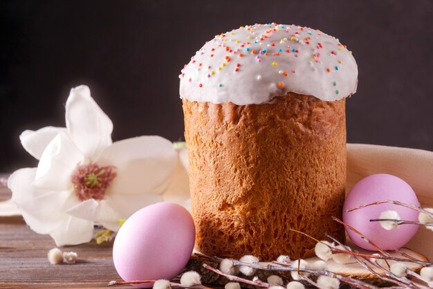 Pastel de Pascua con ramitas de sauce y 2 huevos rosas, flor de magnolia,