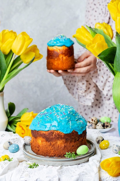 Pastel de Pascua tradicional con glaseado sobre la mesa con ramos de tulipanes