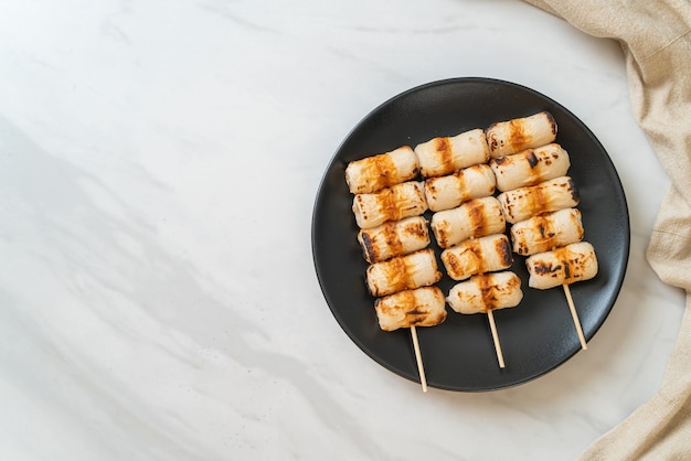 Pastel de pasta de pescado en forma de tubo a la parrilla o pincho de calamar en un plato