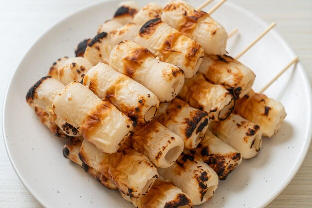 Pastel de pasta de pescado en forma de tubo a la parrilla o tubo de pincho de calamar en un plato