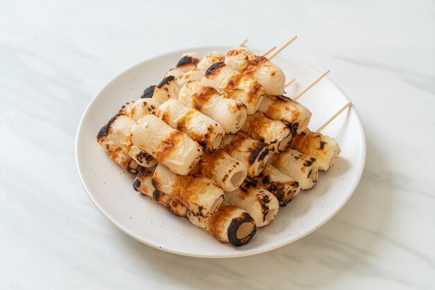 Foto pastel de pasta de pescado en forma de tubo a la parrilla o tubo de pincho de calamar en un plato