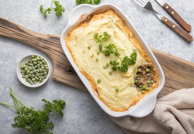 Pastel de pastor con carne molida, patatas y queso sobre fondo de madera, vista superior, espacio de copia. Cazuela irlandesa casera tradicional