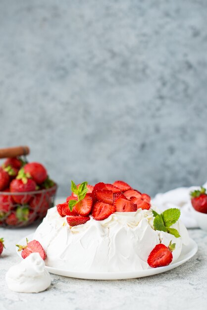 Pastel de Pavlova con merengue y fresas frescas sobre un fondo claro, enfoque selectivo, espacio de copia