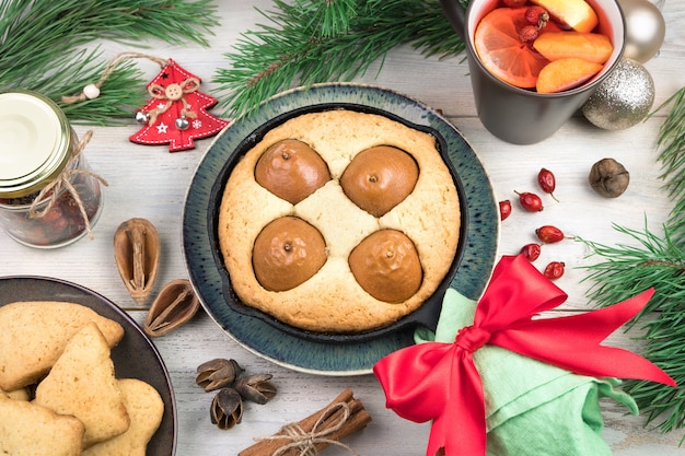 Pastel de pera y galletas sobre fondo de Navidad