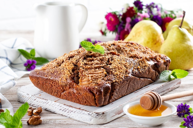 Pastel de pera con nueces y chocolate sobre fondo de madera vieja