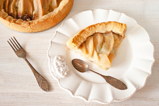 Pastel de peras y queso en un plato sobre la rústica mesa blanca