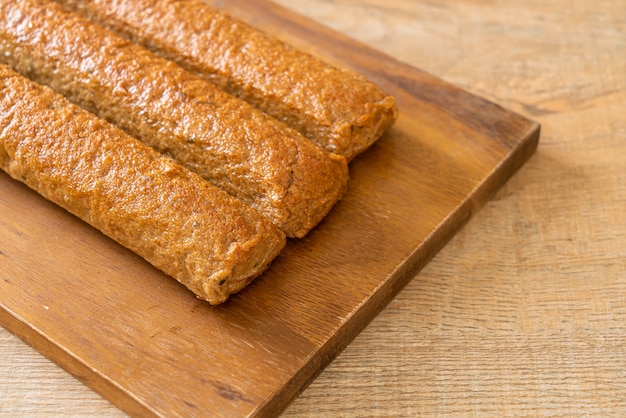 Pastel de pescado chino frito o línea de bolas de pescado sobre tablero de madera