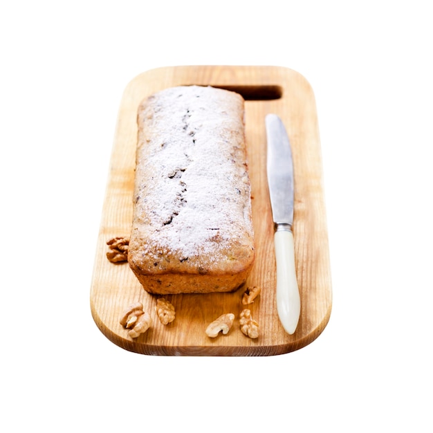 Foto pastel de plátano con nueces sobre tablero de madera aislado en blanco con trazado de recorte