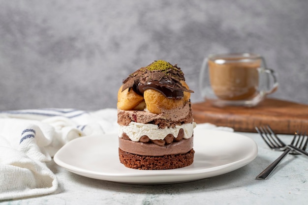 Foto pastel de profiteroles en capas, pastel de crema batida, chocolate y pistacho