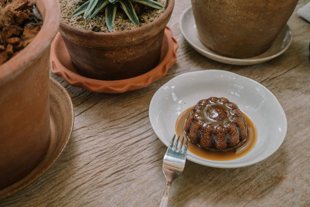 pastel de pudín en la mesa de madera en la cafetería para el concepto de postre