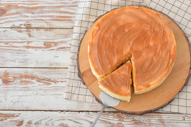 Pastel de queso sabroso en mesa de madera