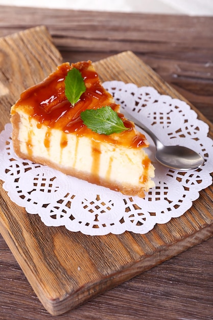 Pastel de queso en una servilleta de papel en una tabla de cortar en una mesa de madera sobre un fondo claro