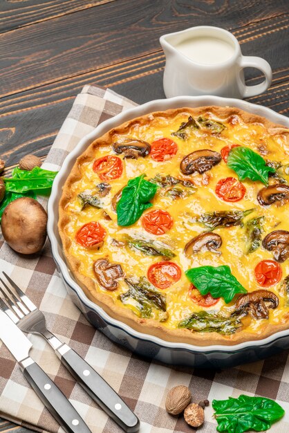 Pastel de quiche casero horneado en forma de cerámica para hornear