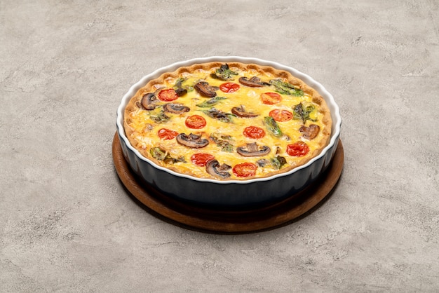 Pastel de quiche casero horneado en forma de cerámica para hornear