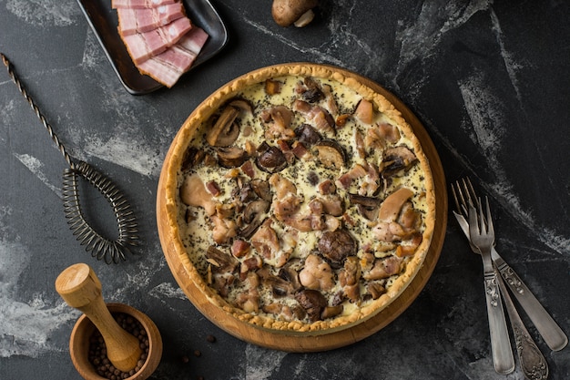 Pastel de quiche de champiñones con champiñones y queso sobre fondo oscuro