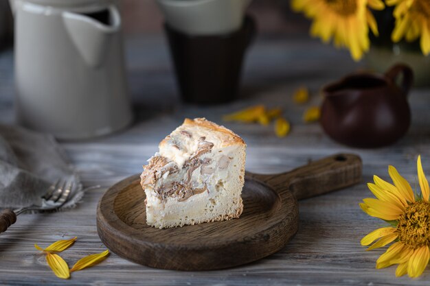 Pastel de quiche con champiñones en una mesa de madera.