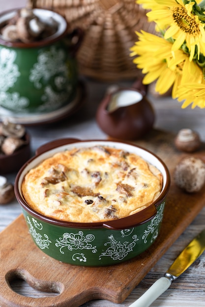 Pastel de quiche con champiñones en una mesa de madera.