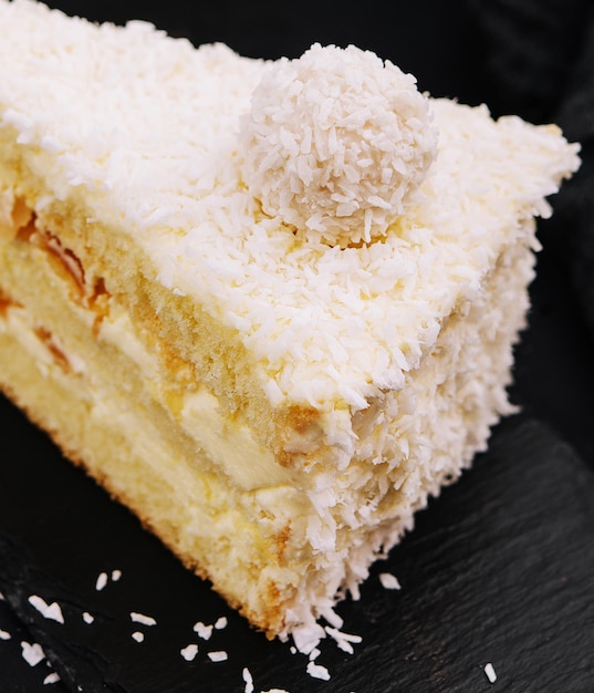 Pastel de raffaello en capas de coco en bandeja negra