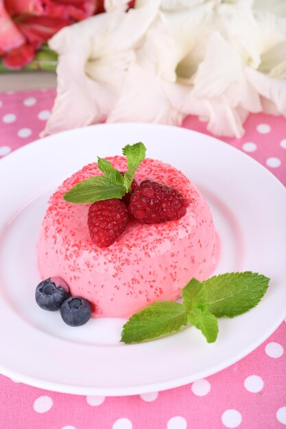 Pastel redondo con bayas en un plato sobre un mantel de lunares