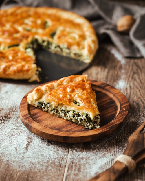 Pastel de relleno de espinacas en la mesa rústica de madera