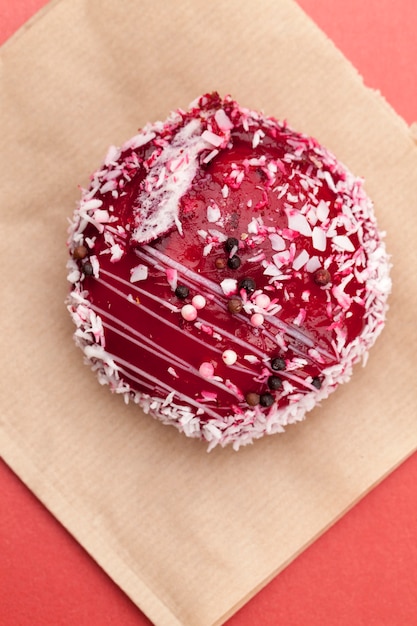 Un pastel rojo con un relleno blanco cremoso, mermelada roja con frambuesas y moras