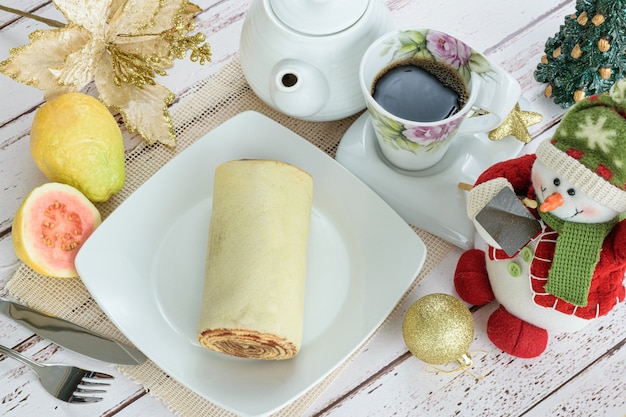 Pastel de rollo de bolo de rolo junto a una decoración navideña Vista superior del dulce tradicional brasileño.