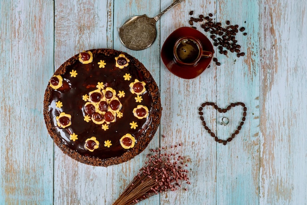 Pastel de ron de chocolate con café y anillo en mesa de madera