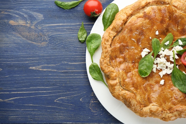 Pastel sabroso con espinacas en mesa