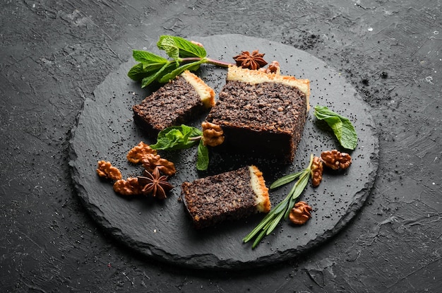 Pastel de semillas de amapola con postre de chocolate y nueces Sobre un fondo negro Vista superior