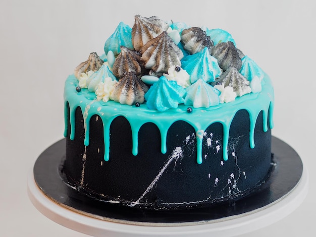 Pastel de taza pintado de negro helado con goteo azul turquesa