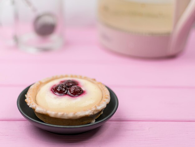 Pastel y té en un vaso sobre un fondo de madera rosa