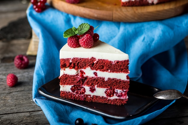 Pastel de terciopelo rojo sobre tablero de madera. Rebanada de pastel. Pastel de frambuesa Pastel de diablo. Postre de boda Pastel de cumpleaños.