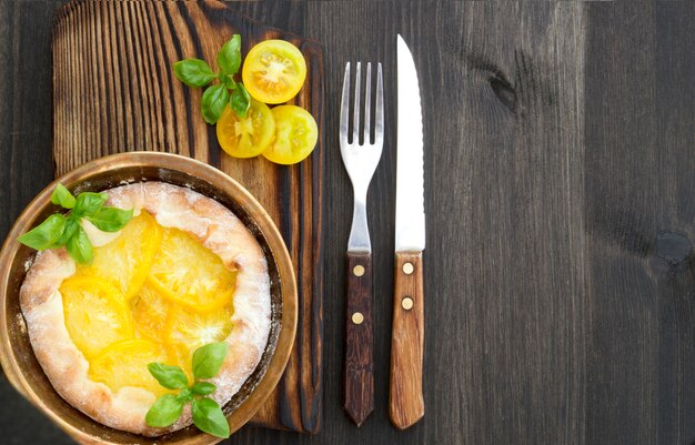 Pastel de tomate amarillo sobre una plancha de madera.