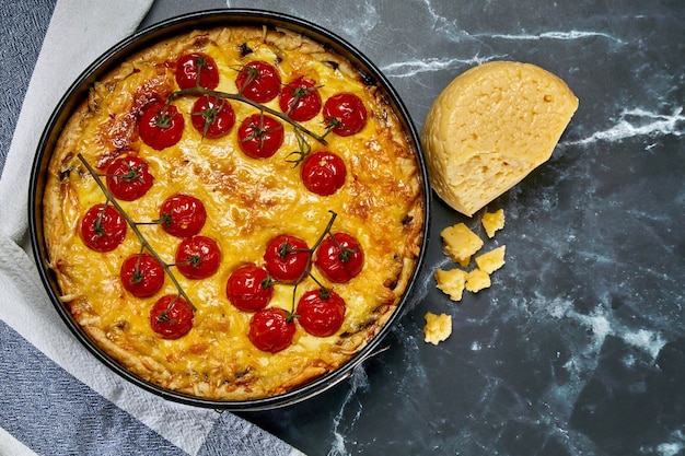 Pastel con tomates cherry enteros al horno en rama y pollo, relleno de crema, queso y huevos