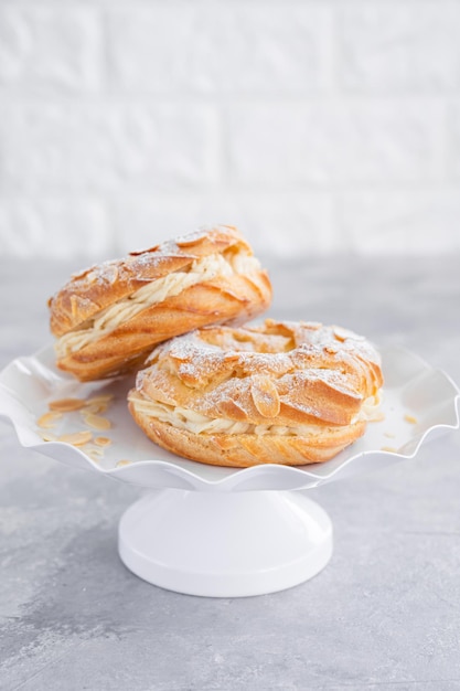 Pastel tradicional francés Paris Brest con crema de praliné azúcar en polvo y pétalos de almendra