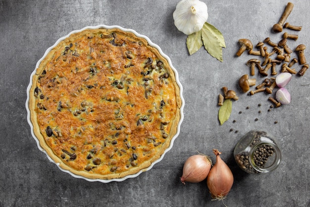 Pastel tradicional francés Quiche Lorraine con champiñones, patatas, queso, cebolla y condimentos.